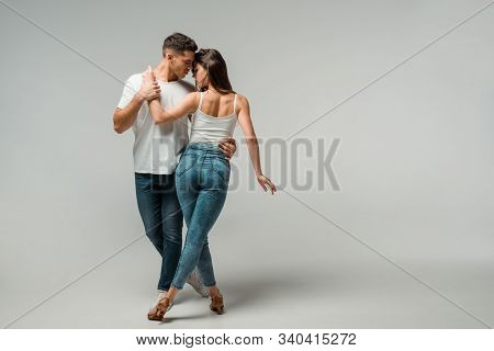 Dancers In Denim Jeans Dancing Bachata On Grey Background