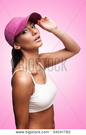 Tan vrouw in roze pet met hoofd omhoog hield
