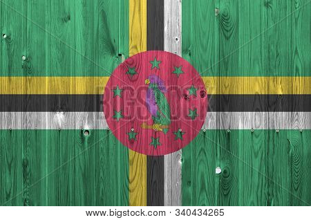 Dominica Flag Depicted In Bright Paint Colors On Old Wooden Wall. Textured Banner On Rough Backgroun