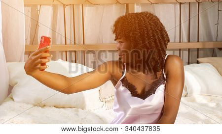 Beautiful Black Lady Makes Selfie Straitening Curly Hair And Holding Modern Smartphone In Hands Clos