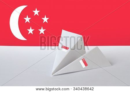 Singapore Flag Depicted On Paper Origami Airplane. Handmade Arts Concept