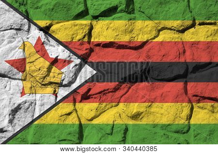 Zimbabwe Flag Depicted In Paint Colors On Old Stone Wall Closeup. Textured Banner On Rock Wall Backg