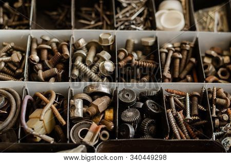 Used And New Bolts, Nuts, Grovers, Bearings. Compartments Of A Plastic Box With Various Fasteners An