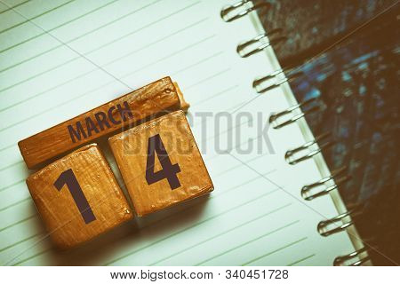 March 14th. Day 14 Of Month, Handmade Wood Cube With Date Month And Day Placed On A Lined Notebook O