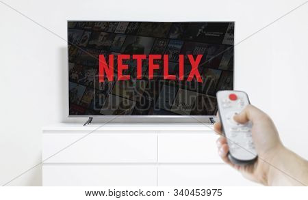 Ufa, Russia - Jule 7, 2019: Table With Popcorn Bottle And Netflix Logo On Smartphone. Netflix Is A G
