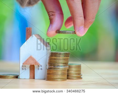 House Or Home Model And A Container For Saving Money On Near Of Coins Stack. Concept For Loan, Prope