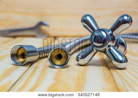Cruciform Hot And Cold Water Main Switch Water Hose On Wooden Boards