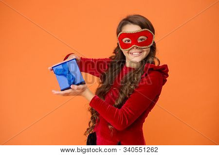 Winter Carnival. Secret Santa Gift Concept. Kid Wear Eye Mask. Girl In Mask Orange Background. Winte