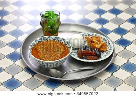 moroccan ramadan iftar meal, harira soup, chebakia, dates, mint tea and khubz