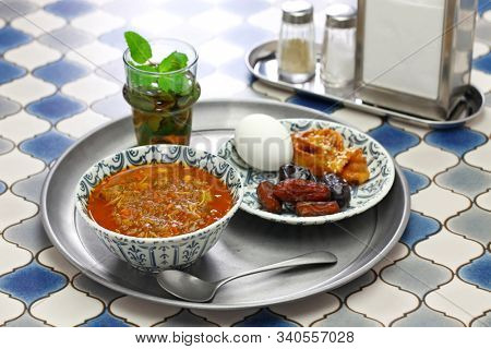 moroccan ramadan iftar meal, harira soup, chebakia, dates, mint tea and khubz