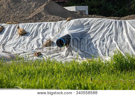 Plastic Sheeting Laying Over Dirt In City Construction Along Hillside