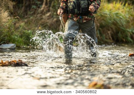Close-up view of the hands of a fly fisherman holding a lovely trout while  fly fishing on a splendid mountain river