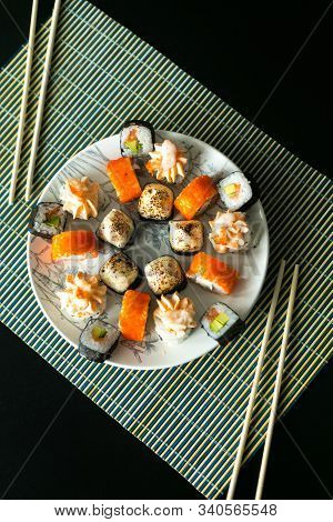 Set Of California Rolls, Butter Cream, Shrimp On A White Platter And A Black Table. With Ginger Soy 