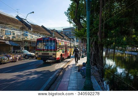 Bangkok, Thailand - November 26, 2019: City bus on road next to Khlong Khu Mueang Doem canal