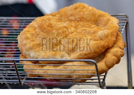 Freshly Baked Langos Offered On The Market. Hungarian Speciality, A Deep Fried Flat Bread Made Of Po