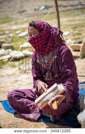 Tso Kar, India - 20 August, 2019: Unidentified Woman From A Nomadic Tribe, Card Wool Fiber In Front 