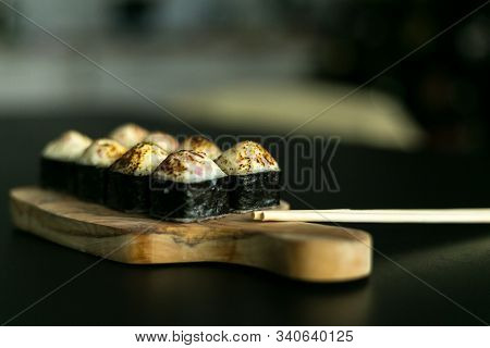Rolls On A Wooden Board And A Black Table With Sticks. Side View
