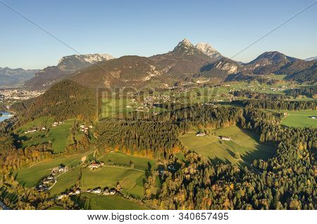 Aerial View Of Green Meadows With Villages And Forest In Austrian Alps Mountains.