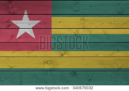 Togo Flag Depicted In Bright Paint Colors On Old Wooden Wall. Textured Banner On Rough Background
