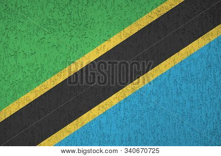 Tanzania Flag Depicted In Bright Paint Colors On Old Relief Plastering Wall. Textured Banner On Roug