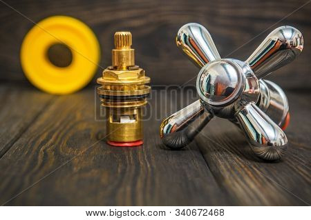 Cruciform Hot And Cold Water Main Switch Of Spare Parts On Black Wooden Boards