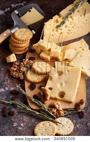 Pieces Of Cheese, Nuts, Raisins, Snacks For Wine On A Wooden Background. Appetitive Copy Space
