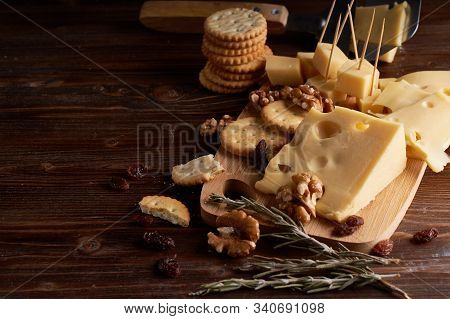 Pieces Of Cheese, Nuts, Raisins, Snacks For Wine On A Wooden Background. Appetitive