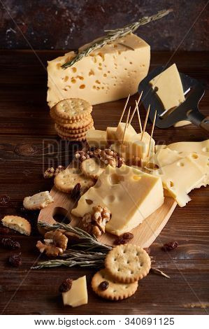 Pieces Of Cheese, Nuts, Raisins, Snacks For Wine On A Wooden Background. Appetitive