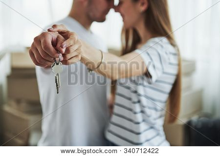 Image Focus Technique. House Keys. Cheerful Young Couple In Their New Apartment. Conception Of Movin