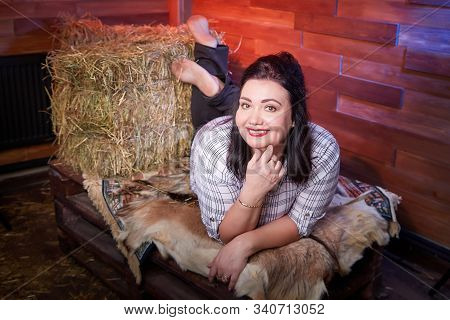 Portrait Of Fat Plump Fun Charming Cute Woman With Black Hair In The Room With Hay And Straw