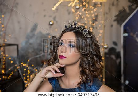 Beautiful Brunette Girl With A Golden Crown, Earrings And Professional Evening Make-up. Beauty Face.