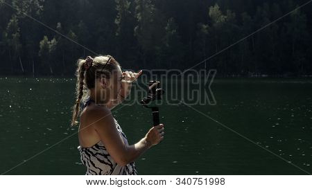 Woman Shooting On Handheld Film Gimbal Stabilization For Smartphone. Girl Stand On Pier Make Selfie.