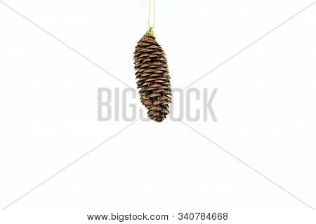 Hanging Christmas Fir Cone On White Background. Greeting Card. New Years Holidays.