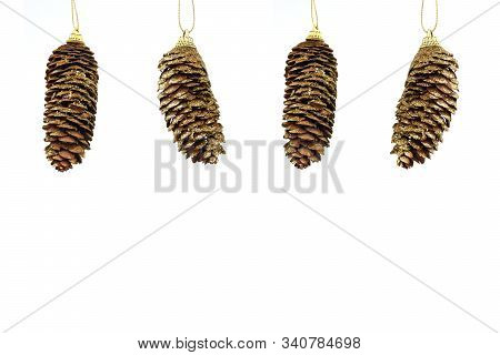 Hanging Pattern Of Four Gold Coloured Fir Cones Isolated On White Background. Greeting Card. New Yea
