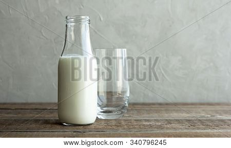A Glass Bottle With Kefir, Milk Or Homemade Fresh Yogurt Stands On A Rustic Table And Next To It Is 