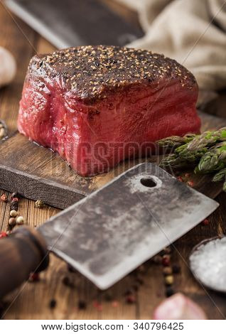 Slice Of Raw Beef Topside Joint With Salt And Pepper On Wooden Chopping Board With Meat Hatchet, Gar