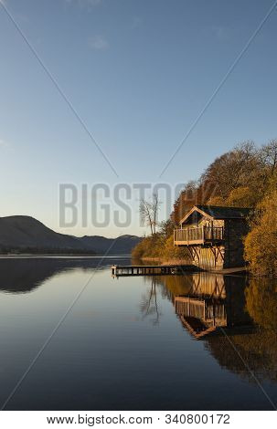 Stunning Sunrise Autumn Fall Landscape Image Of Ullswater In Lake District With Golden Sunlight