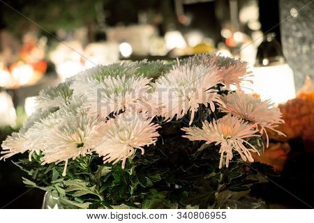 Old White Fake Flower On Grave Candlelit