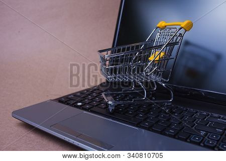 E-commerce, Concept. Online Shopping, Shopping Cart On Laptop Keyboard. Shopping In Online Stores An