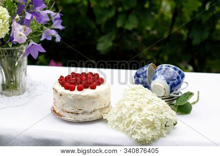 Raspberry Homemade Cake, Hydrangea Branch, Bouquet In A Vase On A Table In The Summer Garden