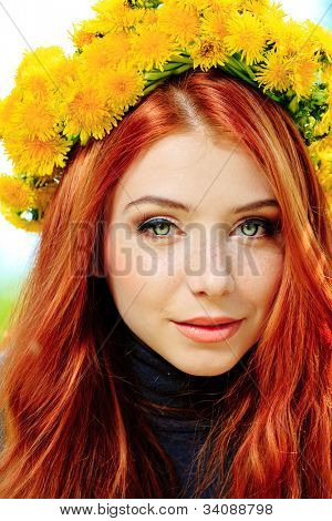 Portræt af en romantisk ung kvinde i en tudorroser af blomster udendørs.