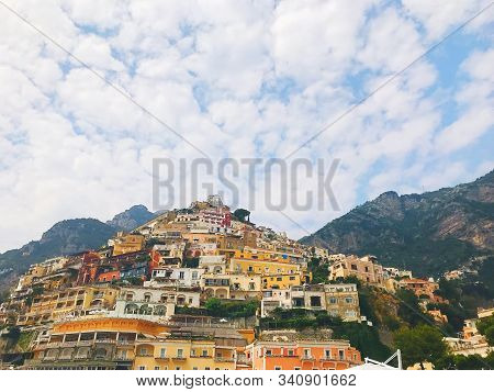 Beautiful Positano View On Mountains With Colorful Houses And White Clody Sky On Sunny Day Photo.