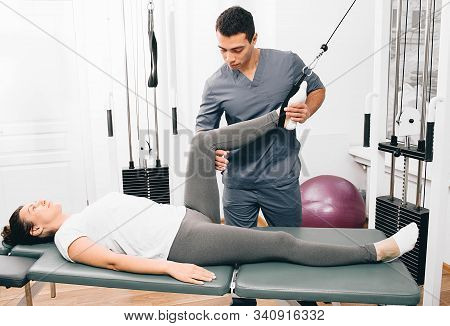 Kinesiologist Doing Therapeutic Exercises For A Woman. Kinesitherapy At The Medical Center