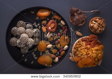 Natural Healthy Raw Energy Bites, Chocolate Paste And Mix Of Dried Fruits With Nuts On A Dark Table.