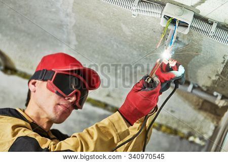 electrician service. Installer works with cable in junction box