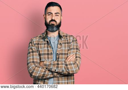 Hispanic man with beard with arms crossed gesture puffing cheeks with funny face. mouth inflated with air, catching air. 
