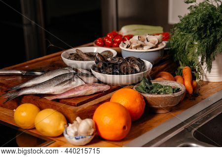 Sea Bream And Shells On The Table Next To Vegetables And Fruit. Ingredients For Making A Delicious S