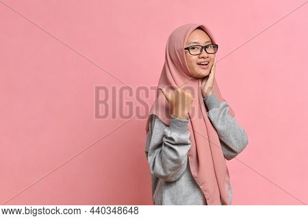 Young Asian Muslim Woman Showing Thumb Up Against Pink Colour Background. Mock Up Copy Space. Showin
