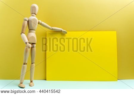 Wooden Human Mannequin Talking Or Presentation, Standing Talking, Empty Space For Text. Yellow Backg