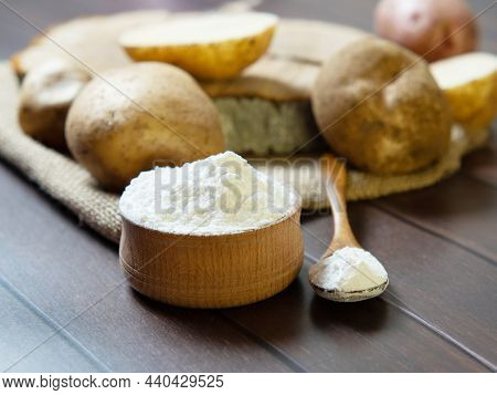 Potato Starch With Potatoes On A Dark Wooden Background.